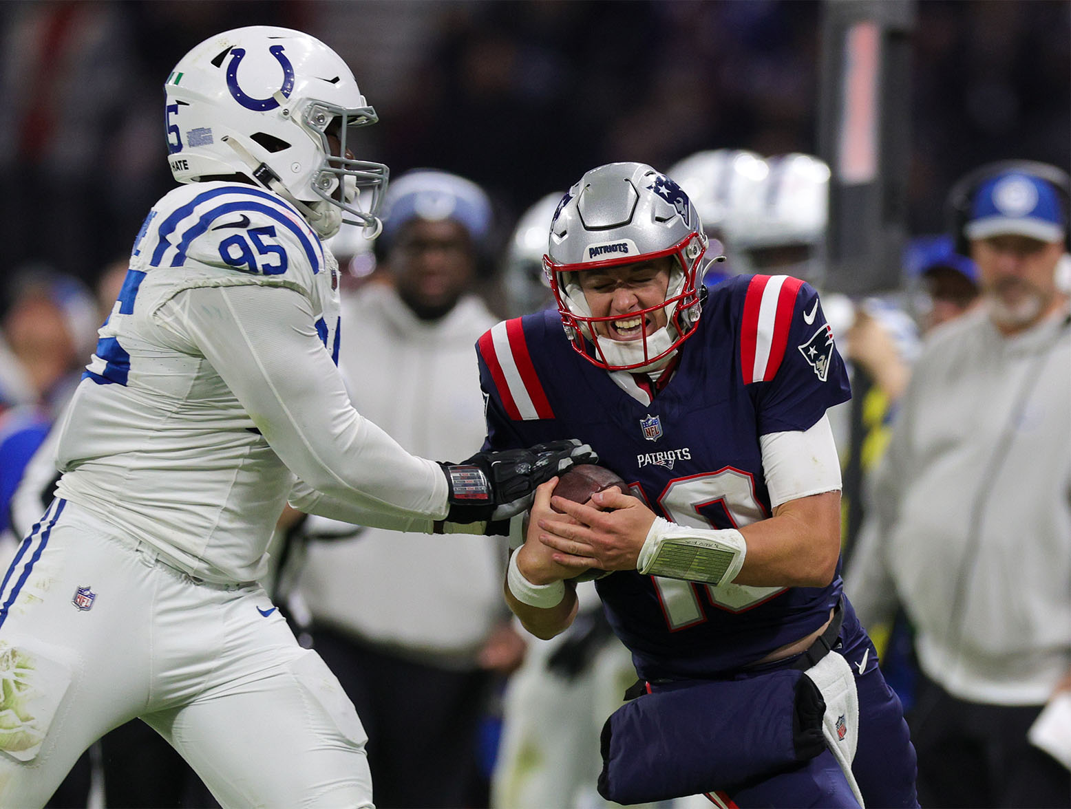 Nov 12, 2023; Frankfurt, Germany; New England Patriots quarterback Mac Jones (10) is forced out of bounds by Indianapolis Colts defensive end Adetomiwa Adebawore (95) in the third quarter during an International Series game at Deutsche Bank Park. Mandatory Credit: Nathan Ray Seebeck-USA TODAY Sports