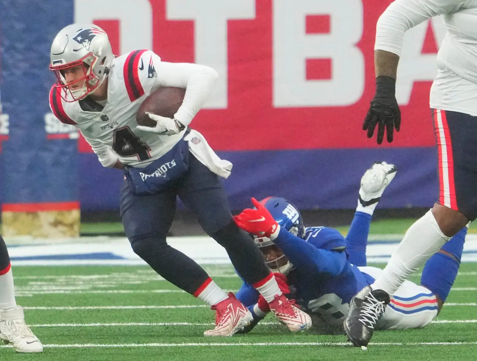 Nov 26, 2023; East Rutherford, New Jersey, USA; New England Patriots quarterback Bailey Zappe (4) breaks free of New York Giants linebacker Bobby Okereke (58) in the 3rd quarter at MetLife Stadium. Credit: Robert Deutsch-USA TODAY Sports