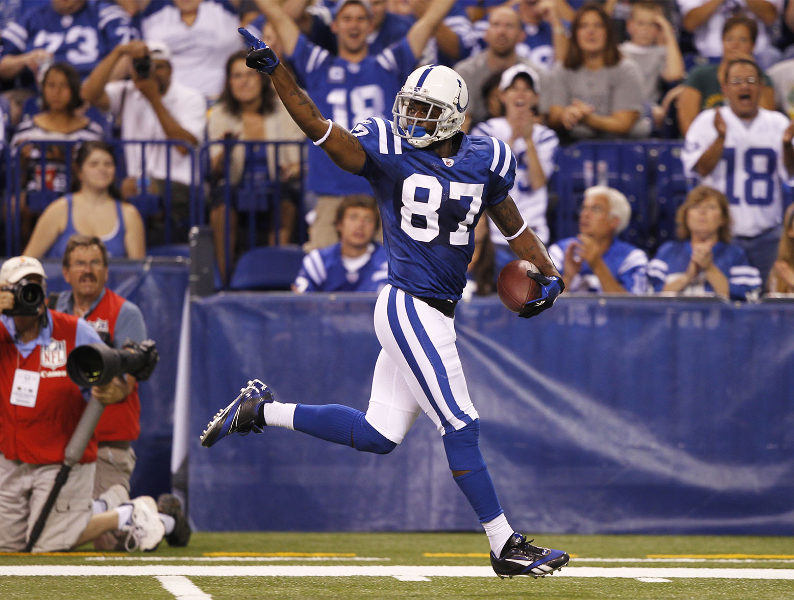 INDIANAPOLIS, IN - AUGUST 26: Reggie Wayne #87 of the Indianapolis Colts runs down the sideline on a 57-yard touchdown reception during the first half of an NFL preseason game against the Green Bay Packers at Lucas Oil Stadium on August 26, 2011 in Indianapolis, Indiana. (Photo by Joe Robbins/Getty Images)