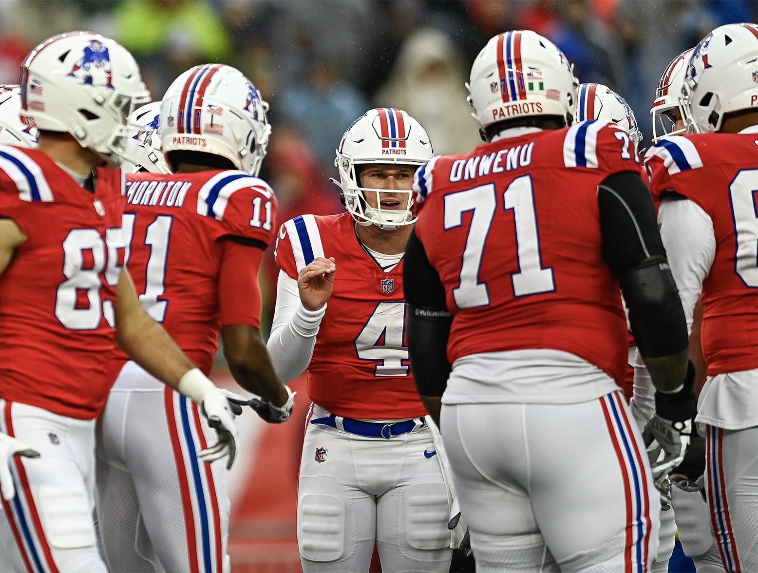 FOXBOROUGH, MASSACHUSETTS - DECEMBER 03: Bailey Zappe #4 of the New England Patriots huddles with the team in the first quarter against the Los Angeles Chargers at Gillette Stadium on December 03, 2023 in Foxborough, Massachusetts. (Photo by Billie Weiss/Getty Images)