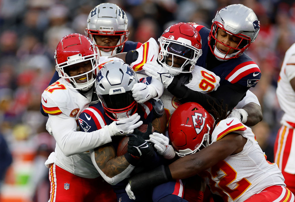 FOXBOROUGH, MASSACHUSETTS - DECEMBER 17: Chamarri Conner #27, Charles Omenihu #90, and Nick Bolton #32 all of the Kansas City Chiefs tackle Ezekiel Elliott #15 of the New England Patriots during the fourth quarter at Gillette Stadium on December 17, 2023 in Foxborough, Massachusetts. (Photo by Sarah Stier/Getty Images)