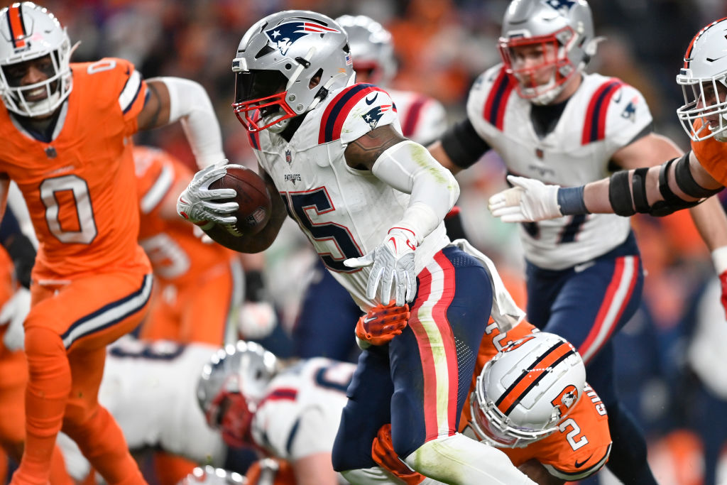 DENVER, COLORADO - DECEMBER 24:  Running back Ezekiel Elliott #15 of the New England Patriots carries the ball during the 1st quarter of the game against the Denver Broncos at Empower Field At Mile High on December 24, 2023 in Denver, Colorado. (Photo by Dustin Bradford/Getty Images)