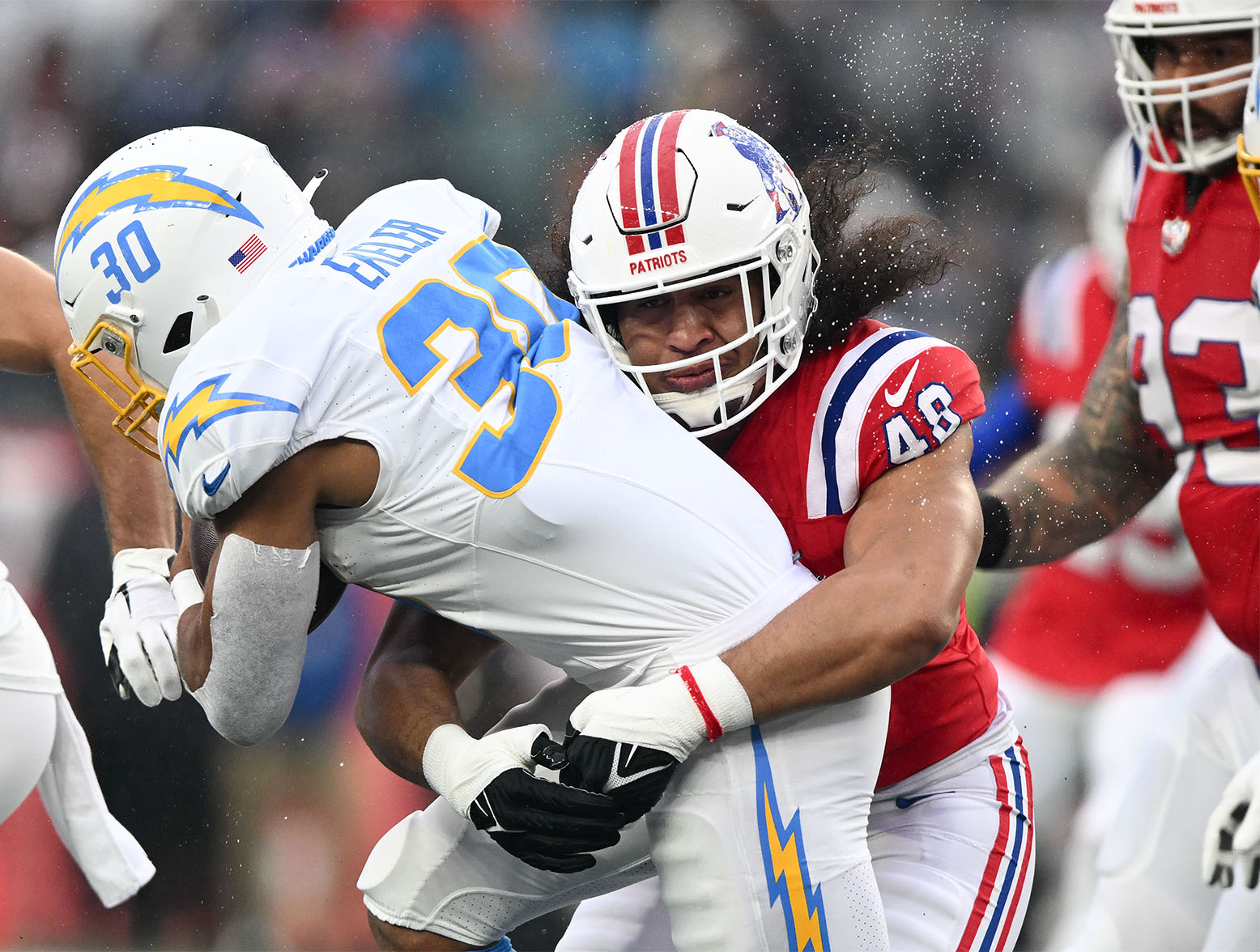 Dec 3, 2023; Foxborough, Massachusetts, USA; New England Patriots linebacker Jahlani Tavai (48) tackles Los Angeles Chargers running back Austin Ekeler (30) during the first half at Gillette Stadium. Mandatory Credit: Brian Fluharty-USA TODAY Sports