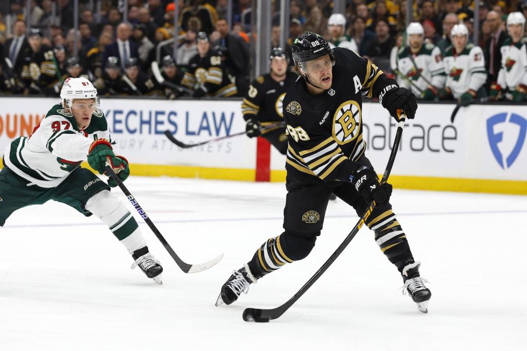 Dec 19, 2023; Boston, Massachusetts, USA; Boston Bruins right wing David Pastrnak (88) lets go with a shot in front of Minnesota Wild left wing Kirill Kaprizov (97) during the first period at TD Garden. Mandatory Credit: Winslow Townson-USA TODAY Sports