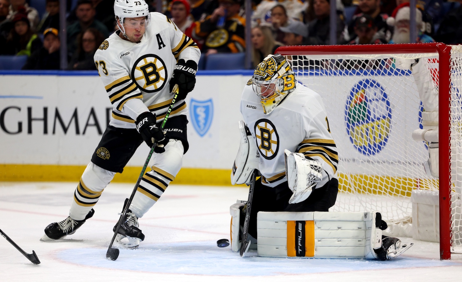 Dec 27, 2023; Buffalo, New York, USA;  Boston Bruins defenseman Charlie McAvoy (73) watches as goaltender Jeremy Swayman (1) makes a save during the second period against the Buffalo Sabres at KeyBank Center. Mandatory Credit: Timothy T. Ludwig-USA TODAY Sports
