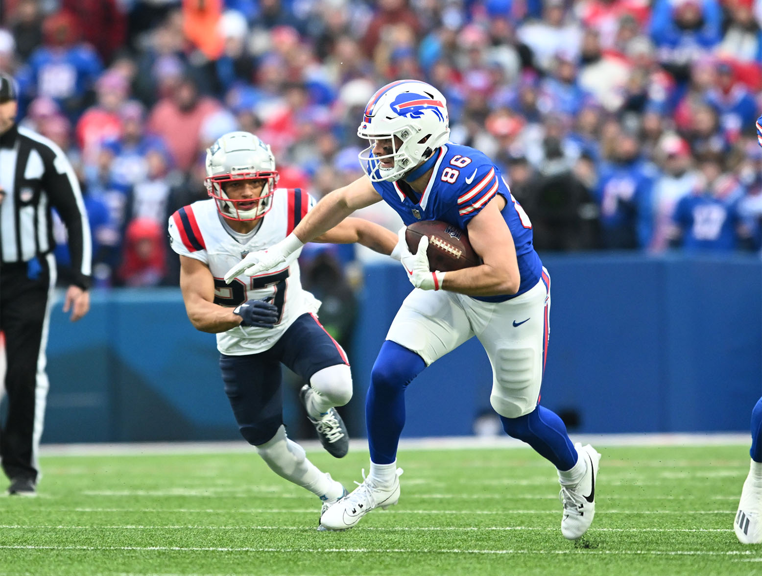 Dec 31, 2023; Orchard Park, New York, USA; Buffalo Bills tight end Dalton Kincaid (86) turns up field after a catch in front of New England Patriots safety Kyle Dugger (23) in the first quarter at Highmark Stadium. Mandatory Credit: Mark Konezny-USA TODAY Sports