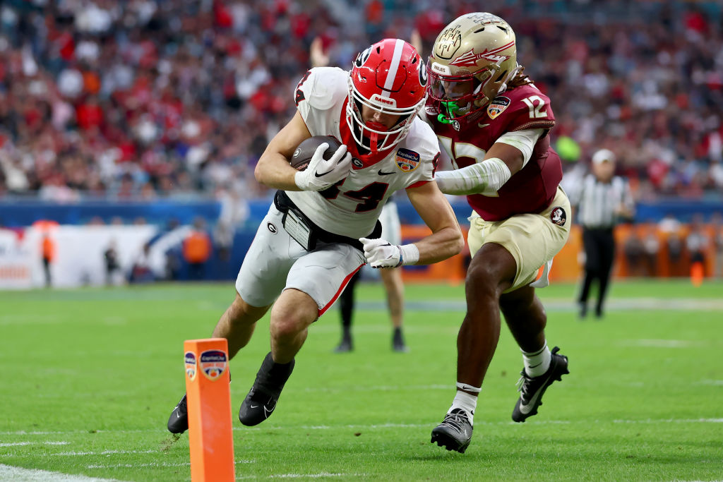 MIAMI GARDENS, FLORIDA - DECEMBER 30: Ladd McConkey #84 of the Georgia Bulldogs scores a touchdown past Conrad Hussey #12 of the Florida State Seminoles in the second quarter during the Capital One Orange Bowl at Hard Rock Stadium on December 30, 2023 in Miami Gardens, Florida. (Photo by Megan Briggs/Getty Images)