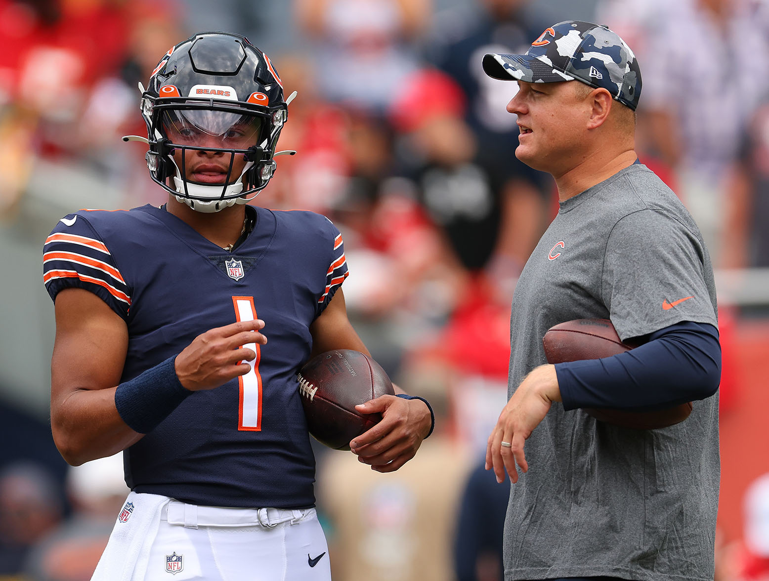 CHICAGO, ILLINOIS - AUGUST 13: Justin Fields #1 of the Chicago Bears talks with offensive coordinator Luke Getsy prior to a preseason game against the Kansas City Chiefs at Soldier Field on August 13, 2022 in Chicago, Illinois. (Photo by Michael Reaves/Getty Images)