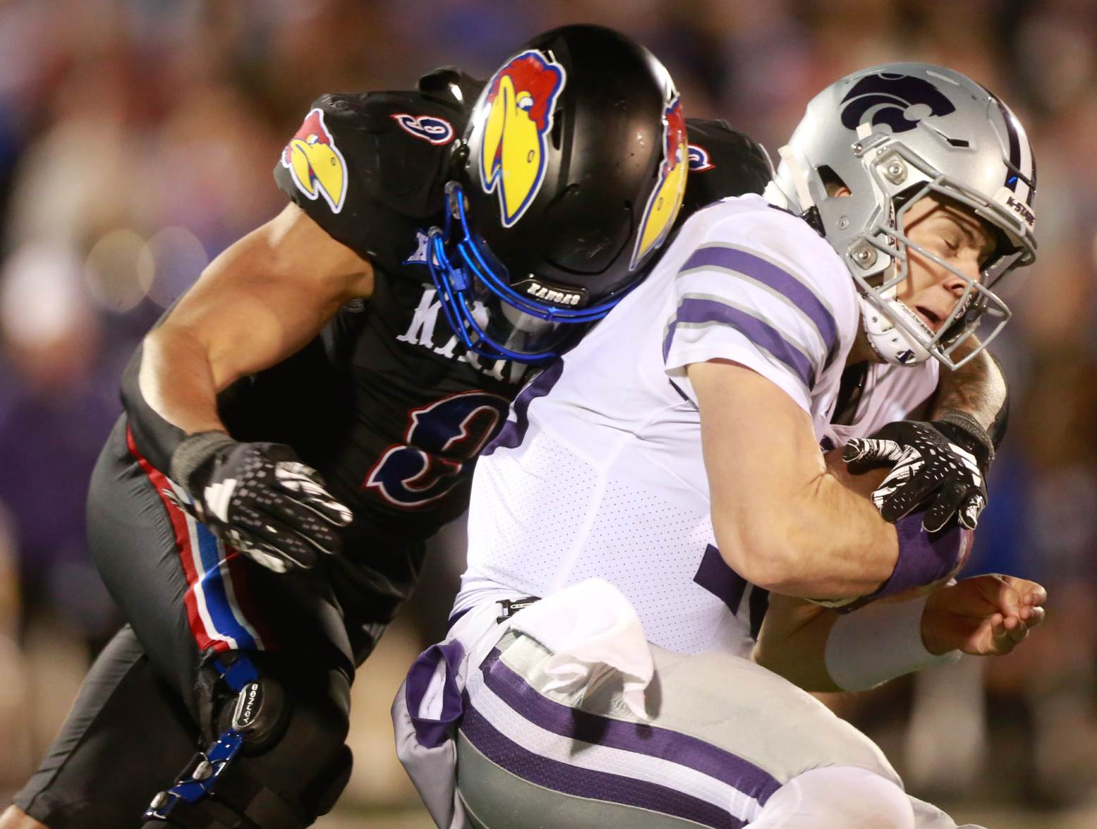 Kansas State senior quarterback Will Howard (18) is sacked by Kansas redshirt sophomore defensive lineman Austin Booker (9) during the fourth quarter of Saturday's Sunflower Showdown inside David Booth Kansas Memorial Stadium. (Evert Nelson/The Capital-Journal/USA Today Network)