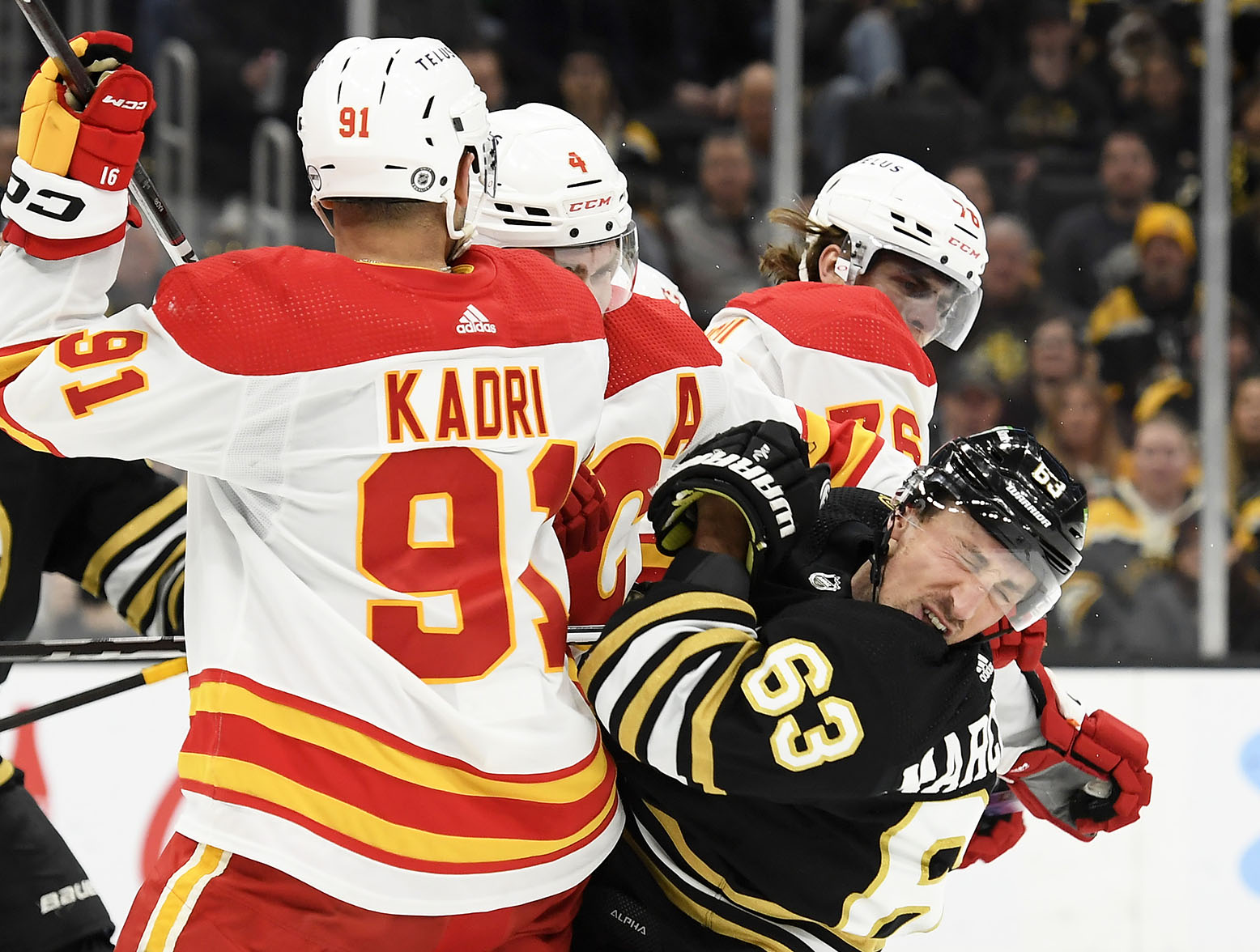 Feb 6, 2024; Boston, Massachusetts, USA; Boston Bruins left wing Brad Marchand (63) reacts after getting a cross check in the face by Calgary Flames center Martin Pospisil (76) during the first period at TD Garden. Mandatory Credit: Bob DeChiara-USA TODAY Sports