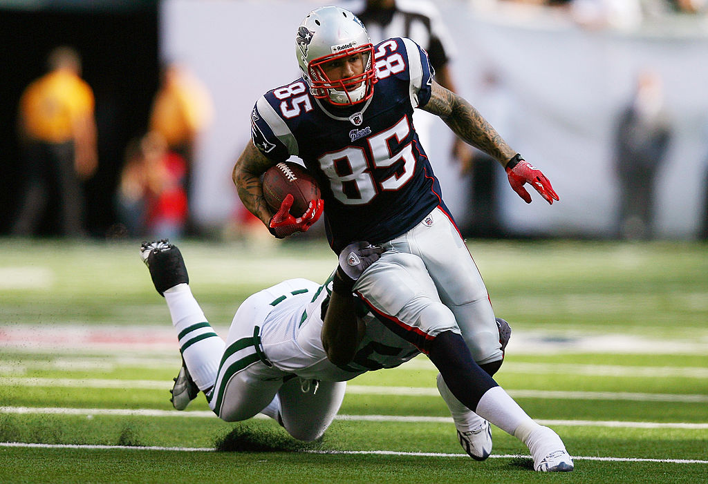 EAST RUTHERFORD, NJ - SEPTEMBER 19:  Aaron Hernandez #85 of the New England Patriots runs through a tackle from David Harris #52 of the New York Jets during the first quarter at the New Meadowlands Stadium on September 19, 2010 in East Rutherford, New Jersey.  (Photo by Andrew Burton/Getty Images)