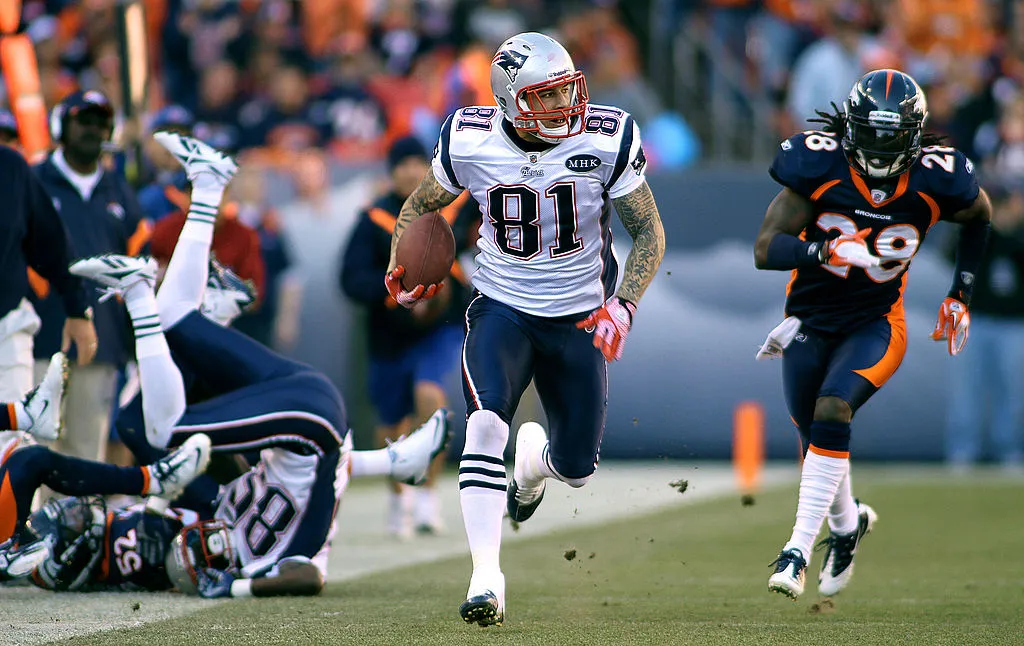 DENVER, CO - DECEMBER 18: Aaron Hernandez #81 of the New England Patriots breaks free on a pass play as Quinton Carter #28 of the Denver Broncos gives chase on December 18, 2011 during the first half at Sports Authority Field at Mile High in Denver, Colorado. (Photo by Marc Piscotty/Getty Images)