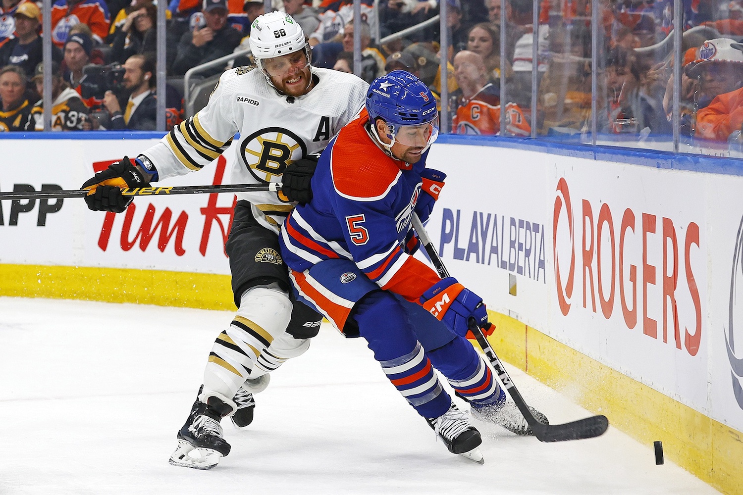 Feb 21, 2024; Edmonton, Alberta, CAN; Edmonton Oilers defensemen Cody Ceci (5) and Boston Bruins forward David Pastrnak (88) Battle along the boards for a loose puck during the second period at Rogers Place. Mandatory Credit: Perry Nelson-USA TODAY Sports