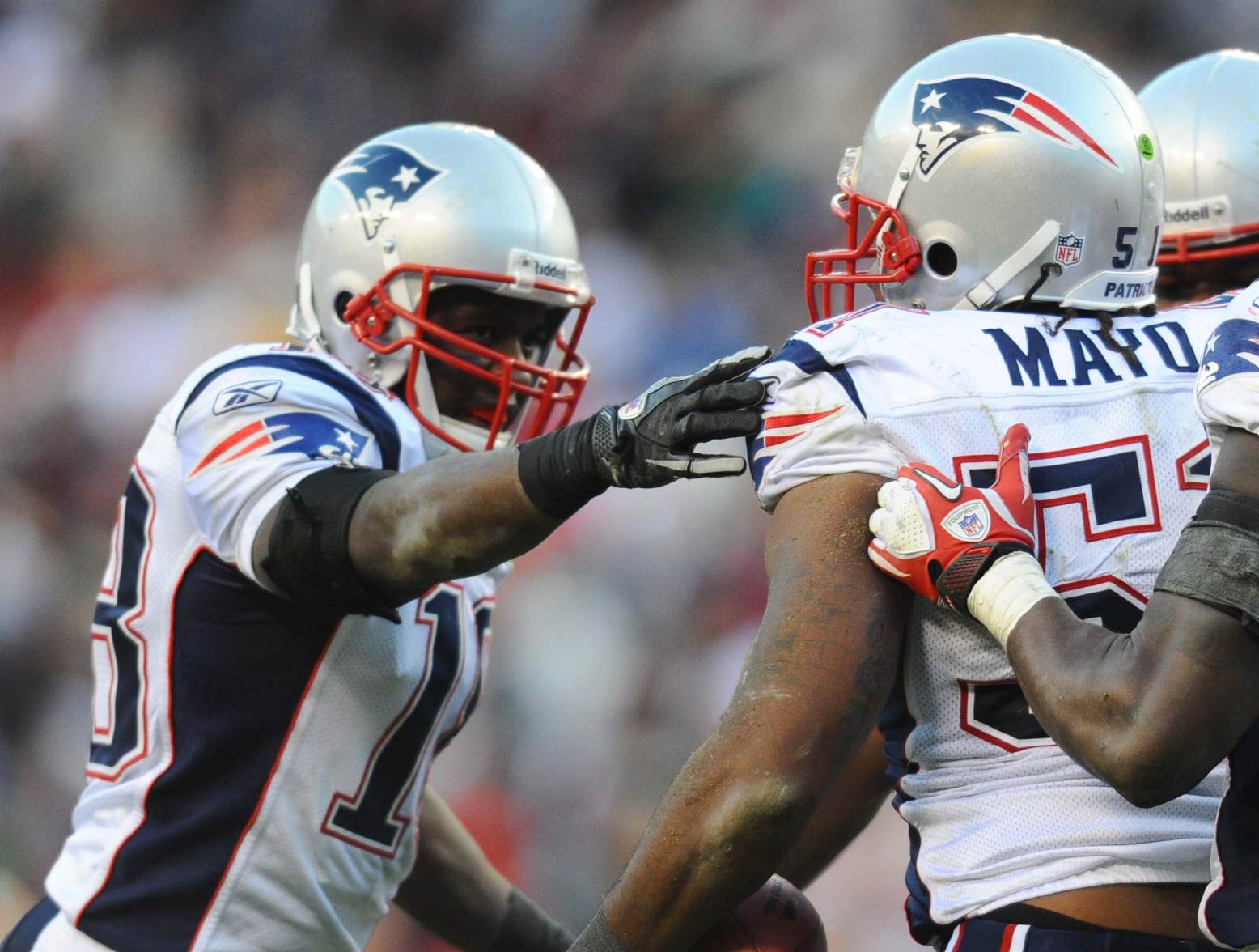 Dec 11, 2011; Landover, MD, USA; New England Patriots linebacker Jerod Mayo (53) is congratulated by defensive back Matthew Slater 18) and safety James Ihedigbo (44) after intercepting a pass against the Washington Redskins in the fourth quarter at FedEx Field. Mandatory Credit: James Lang-US PRESSWIRE