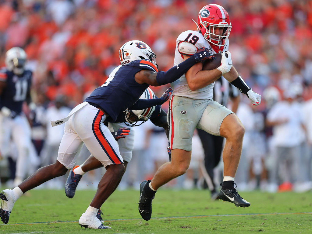 AUBURN, ALABAMA - SEPTEMBER 30: Brock Bowers #19 of the Georgia Bulldogs breaks a tackle by Zion Puckett #10 and D.J. James #4 of the Auburn Tigers on the way to the go-ahead touchdown during the fourth quarter at Jordan-Hare Stadium on September 30, 2023 in Auburn, Alabama. (Photo by Kevin C. Cox/Getty Images)