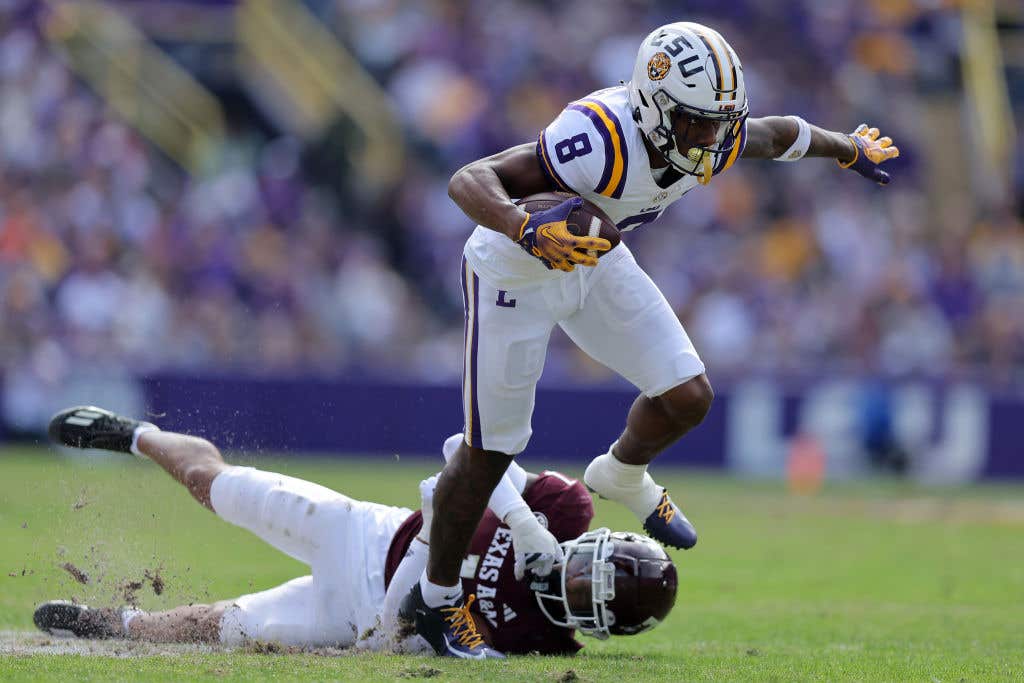 BATON ROUGE, LOUISIANA - NOVEMBER 25: Malik Nabers #8 of the LSU Tigers runs with the ball as Bryce Anderson #1 of the Texas A&amp;M Aggies defends during the first half at Tiger Stadium on November 25, 2023 in Baton Rouge, Louisiana. (Photo by Jonathan Bachman/Getty Images)