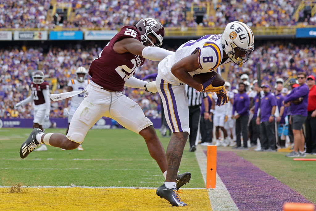 BATON ROUGE, LOUISIANA - NOVEMBER 25: Malik Nabers #8 of the LSU Tigers catches the ball for a touchdown as Demani Richardson #26 of the Texas A&M Aggies defends during the second half at Tiger Stadium on November 25, 2023 in Baton Rouge, Louisiana. (Photo by Jonathan Bachman/Getty Images)