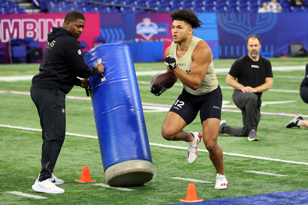 INDIANAPOLIS, INDIANA - MARCH 02: Isaac Guerendo #RB12 of Louisville participates in a drill during the NFL Combine at Lucas Oil Stadium on March 02, 2024 in Indianapolis, Indiana. (Photo by Stacy Revere/Getty Images)