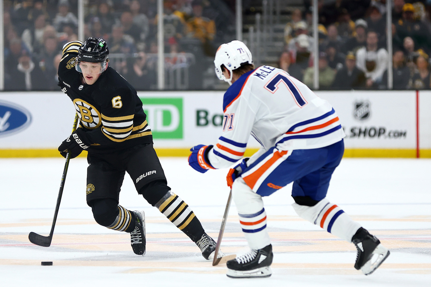 BOSTON, MASSACHUSETTS - MARCH 05: Mason Lohrei #6 of the Boston Bruins skates against Ryan McLeod #71 of the Edmonton Oilers during the first period at TD Garden on March 05, 2024 in Boston, Massachusetts. (Photo by Maddie Meyer/Getty Images)