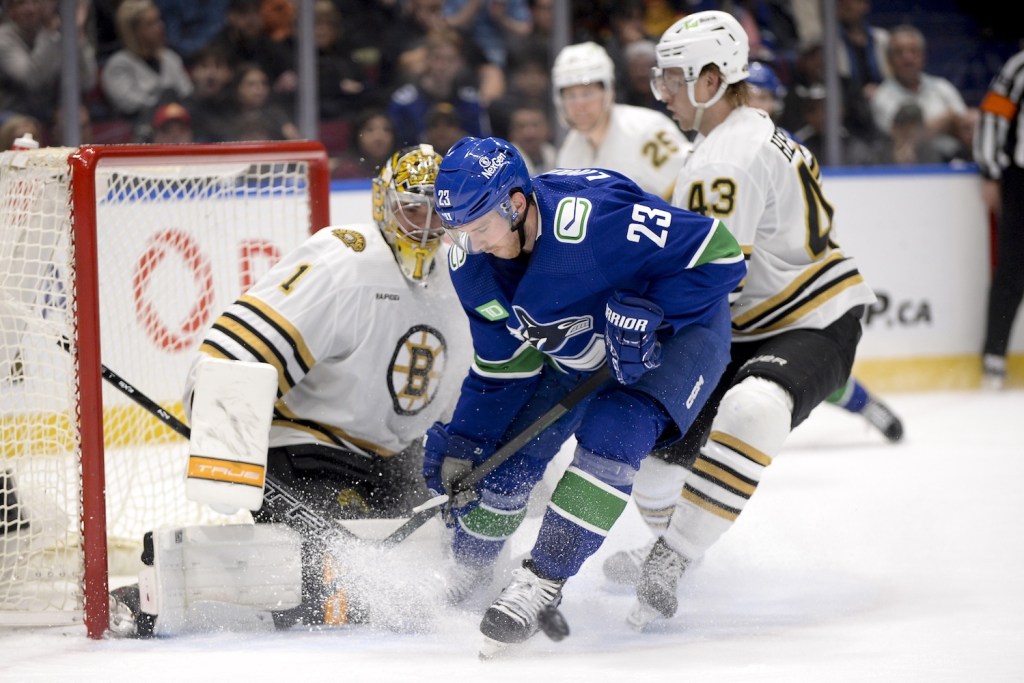 Feb 24, 2024; Vancouver, British Columbia, CAN; Vancouver Canucks forward Elias Lindholm (23) tries to tip the puck defended by Boston Bruins goaltender Jeremy Swayman (1) and forward Danton Heinen (43) during the third period at Rogers Arena. Mandatory Credit: Anne-Marie Sorvin-USA TODAY Sports