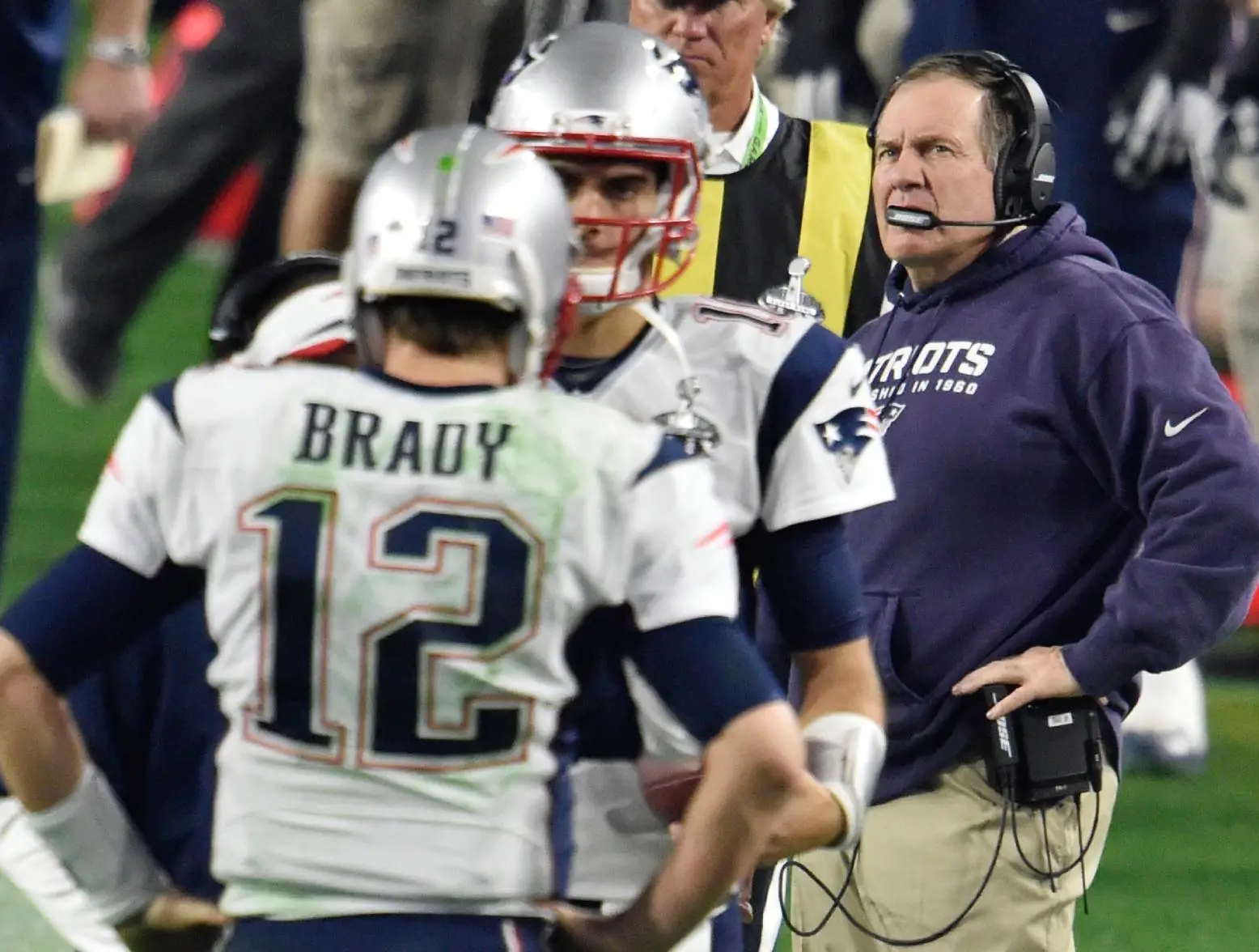Feb 1, 2015; Glendale, AZ, USA; New England Patriots head coach Bill Belichick looks on while quarterback Tom Brady (12) and quarterback Jimmy Garoppolo (10) speak in the foreground during the fourth quarter against the Seattle Seahawks in Super Bowl XLIX at University of Phoenix Stadium. Credit: Joe Camporeale-USA TODAY Sports