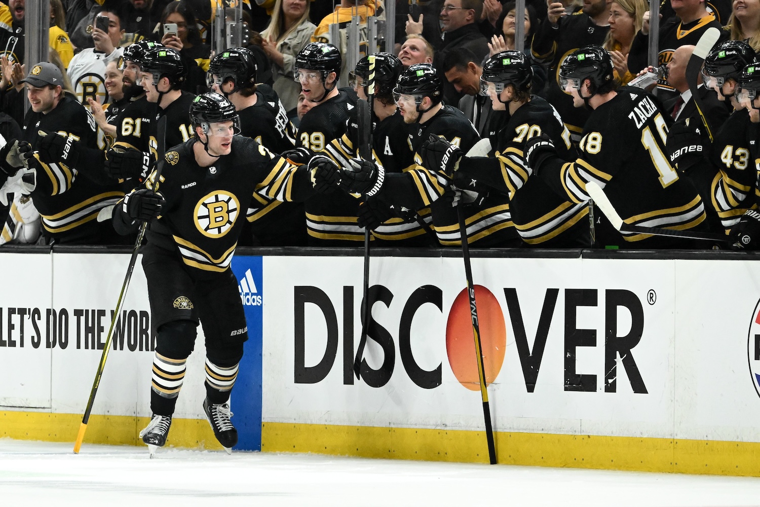 BOSTON, MASSACHUSETTS - APRIL 20: Brandon Carlo #25 of the Boston Bruins skates by the bench to celebrate with his teammates after scoring a goal against the Toronto Maple Leafs during the second period in Game One of the First Round of the 2024 Stanley Cup Playoffs at TD Garden on April 20, 2024 in Boston, Massachusetts. (Photo by Brian Fluharty/Getty Images)