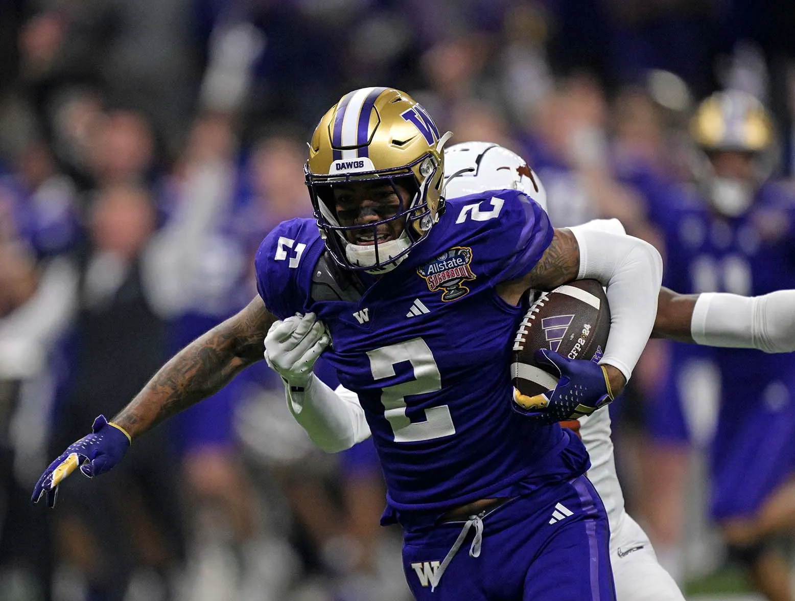 Jan 1, 2024; New Orleans, LA, USA; Washington Huskies wide receiver Ja'Lynn Polk (2) runs the ball after a catch against Texas Longhorns defensive back Terrance Brooks (8) during the first quarter in the 2024 Sugar Bowl college football playoff semifinal game at Caesars Superdome. Mandatory Credit: Matthew Hinton-USA TODAY Sports
