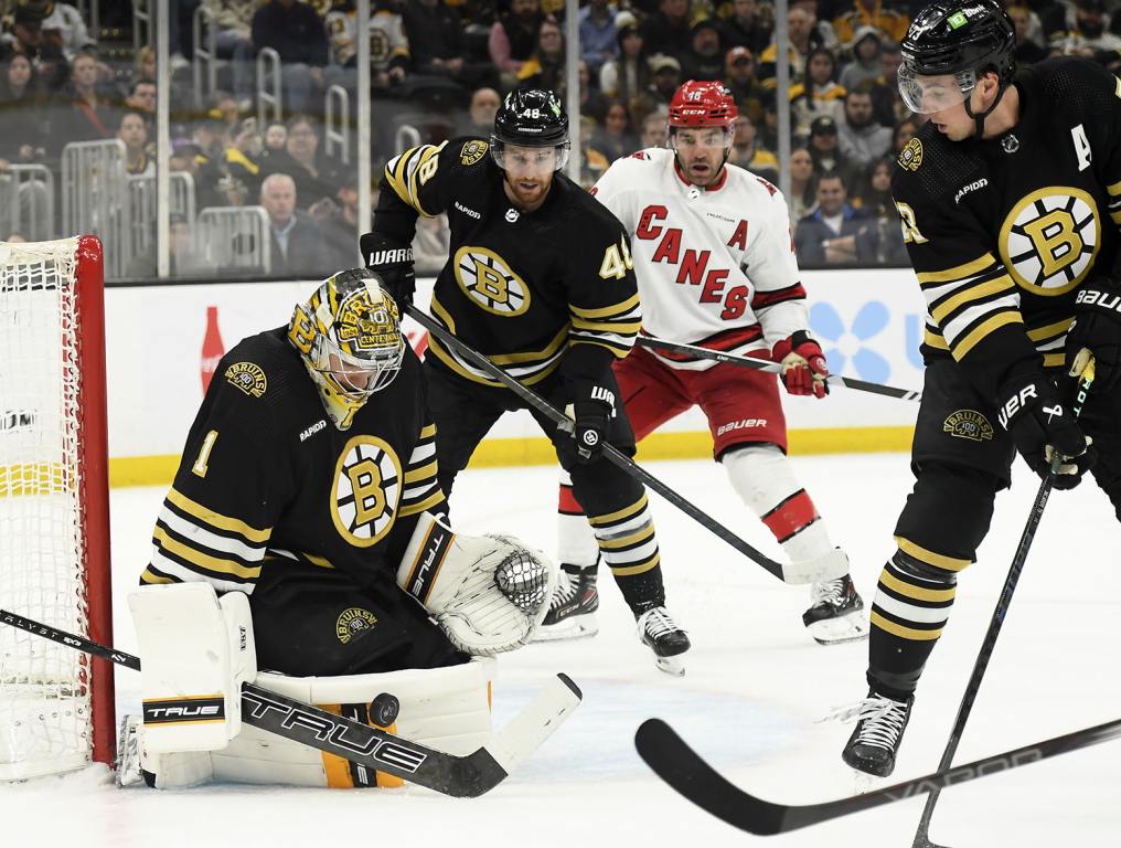 Apr 9, 2024; Boston, Massachusetts, USA; Boston Bruins goaltender Jeremy Swayman (1) makes a save in front of Boston Bruins defenseman while Boston Bruins defenseman Charlie McAvoy (73) looks on during the second period against the Carolina Hurricanes at TD Garden. Mandatory Credit: Bob DeChiara-USA TODAY Sports