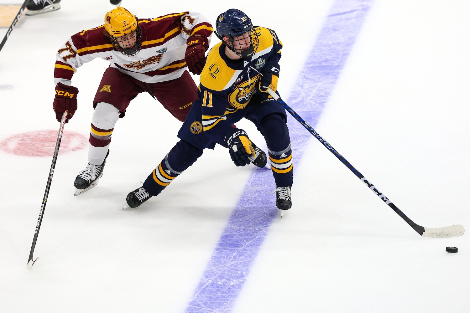 Apr 8, 2023; Tampa, Florida, USA; Quinnipiac forward Collin Graf (11) controls the puck from Minnesota forward Rhett Pitlick (77) in the first period during the national championship game of the 2023 Frozen Four college ice hockey tournament at Amalie Arena. Mandatory Credit: Nathan Ray Seebeck-USA TODAY Sports