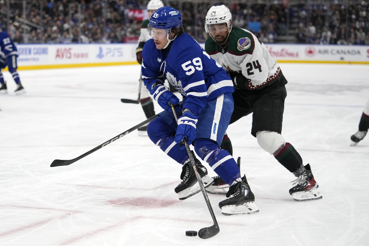 Feb 29, 2024; Toronto, Ontario, CAN; Toronto Maple Leafs forward Tyler Bertuzzi (59) carries the puck past Arizona Coyotes defenseman Matt Dumba (24) during the first period at Scotiabank Arena. Mandatory Credit: John E. Sokolowski-USA TODAY Sports