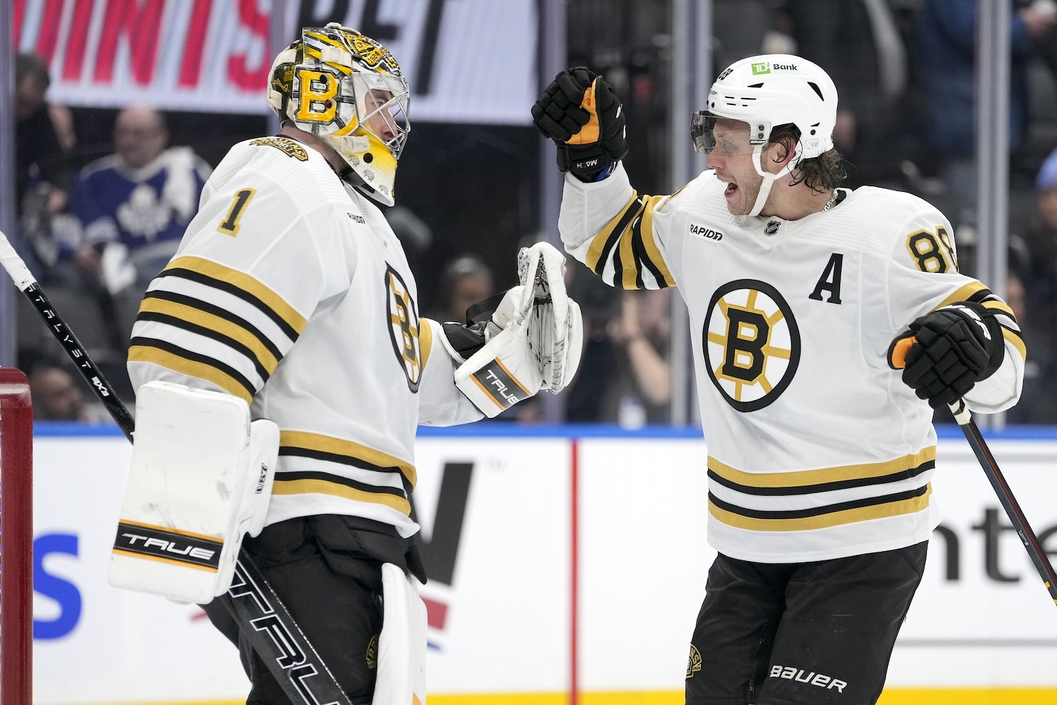 Apr 24, 2024; Toronto, Ontario, CAN;Boston Bruins forward David Pastrnak (88) and goaltender Jeremy Swayman (1) celebrate a win over the Toronto Maple Leafs in game three of the first round of the 2024 Stanley Cup Playoffs at Scotiabank Arena. Mandatory Credit: John E. Sokolowski-USA TODAY Sports