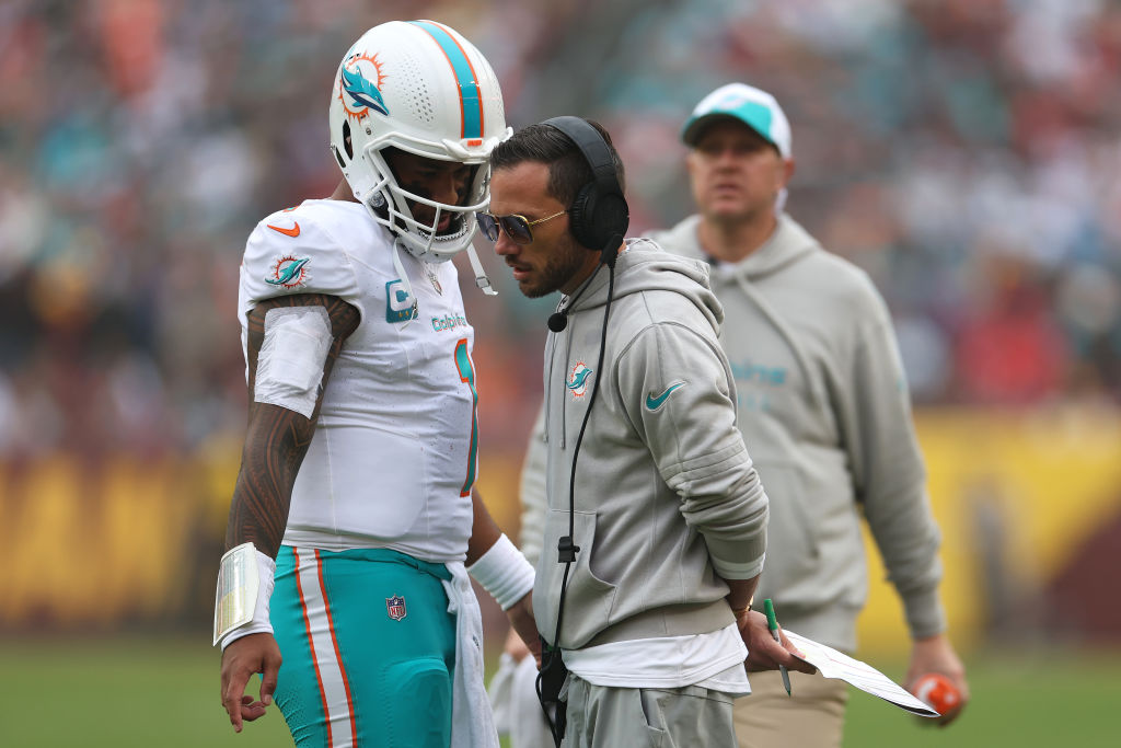 LANDOVER, MARYLAND - DECEMBER 03: Tua Tagovailoa #1 and head coach Mike McDaniel of the Miami Dolphins speak on the field during the second quarter of the game against the Washington Commanders at FedExField on December 03, 2023 in Landover, Maryland. (Photo by Rob Carr/Getty Images)