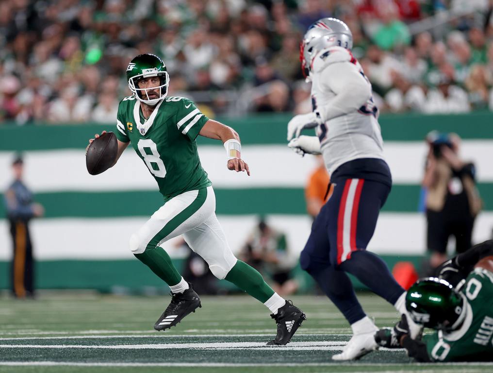 EAST RUTHERFORD, NEW JERSEY - SEPTEMBER 19: Aaron Rodgers #8 of the New York Jets scrambles against the New England Patriots during the third quarter in the game at MetLife Stadium on September 19, 2024 in East Rutherford, New Jersey. (Photo by Sarah Stier/Getty Images)