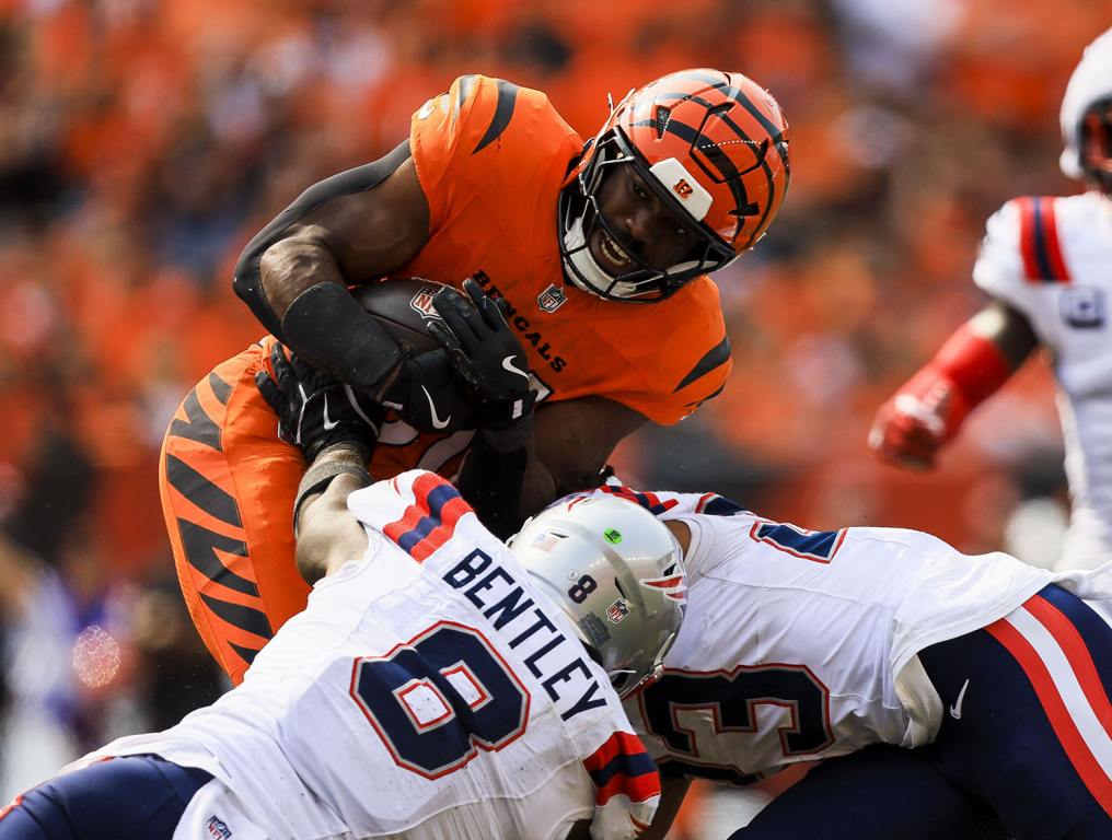 Sep 8, 2024; Cincinnati, Ohio, USA; Cincinnati Bengals running back Zack Moss (31) runs with the ball against New England Patriots linebacker Ja'Whaun Bentley (8) and safety Kyle Dugger (23) in the second half at Paycor Stadium. Mandatory Credit: Katie Stratman-Imagn Images