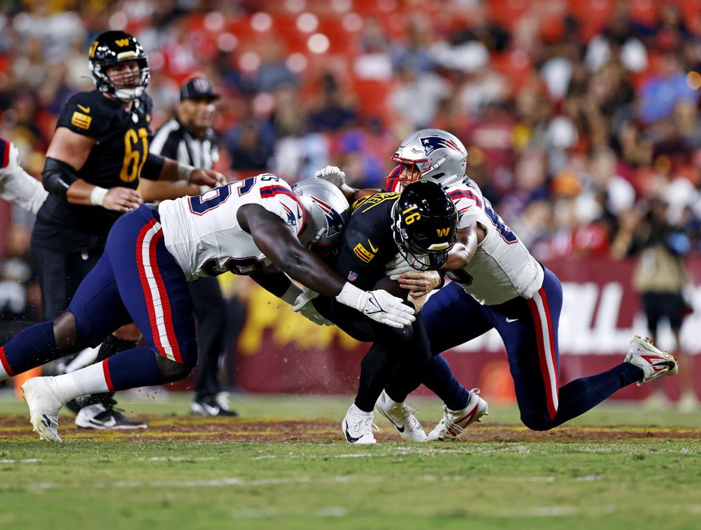 Aug 25, 2024; Landover, Maryland, USA; Washington Commanders quarterback Jeff Driskel (16) runs the ball against New England Patriots defensive tackle Sam Roberts (96) and linebacker Ja'Whaun Bentley (8) during the second quarter during a preseason game at Commanders Field. Mandatory Credit: Peter Casey-USA TODAY Sports