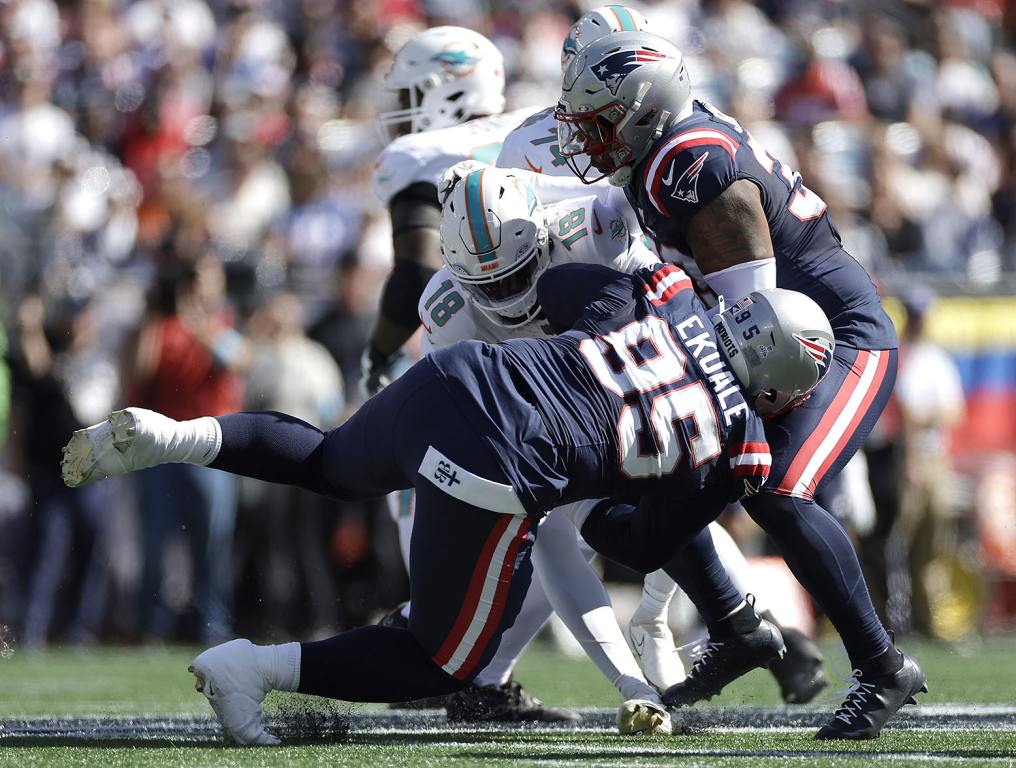 FOXBOROUGH, MASSACHUSETTS - OCTOBER 06: Daniel Ekuale #95 of the New England Patriots tackles Tyler Huntley #18 of the Miami Dolphins during the first quarter at Gillette Stadium on October 06, 2024 in Foxborough, Massachusetts. (Photo by Adam Hunger/Getty Images)