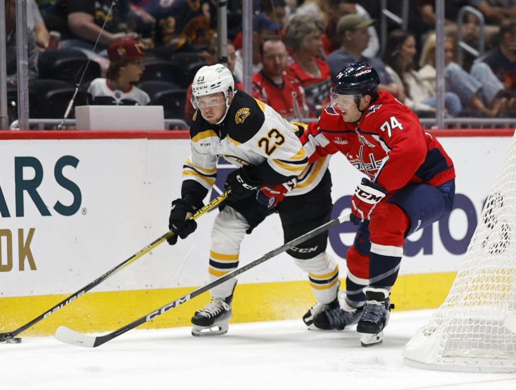 Oct 5, 2024; Washington, District of Columbia, USA; Boston Bruins right wing Fabian Lysell (23) skates with the puck as Washington Capitals defenseman John Carlson (74) defends in the second period at Capital One Arena. Mandatory Credit: Geoff Burke-Imagn Images