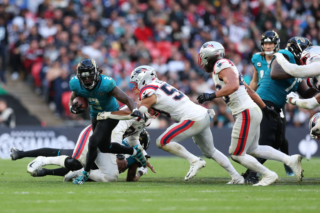 LONDON, ENGLAND - OCTOBER 20: D'Ernest Johnson of Jacksonville Jaguars is challenged by Christian Eliss of New England Patriots during the NFL match between New England Patriots and Jacksonville Jaguars at Wembley Stadium on October 20, 2024 in London, England. (Photo by Julian Finney/Getty Images)