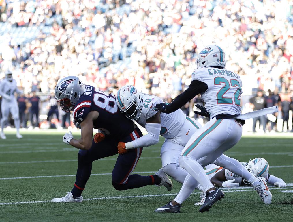 FOXBOROUGH, MASSACHUSETTS - OCTOBER 06: Jordyn Brooks #20 of the Miami Dolphins tackles Hunter Henry #85 of the New England Patriots during the fourth quarter at Gillette Stadium on October 06, 2024 in Foxborough, Massachusetts. (Photo by Adam Hunger/Getty Images)