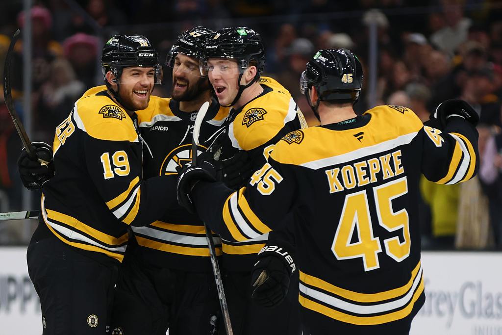 BOSTON, MASSACHUSETTS - OCTOBER 14: John Beecher #19 of the Boston Bruins celebrates with Cole Koepke #45, Mason Lohrei #6, and Mark Kastelic #47 after scoring a goal against the Florida Panthers during the first period at TD Garden on October 14, 2024 in Boston, Massachusetts. (Photo by Maddie Meyer/Getty Images)