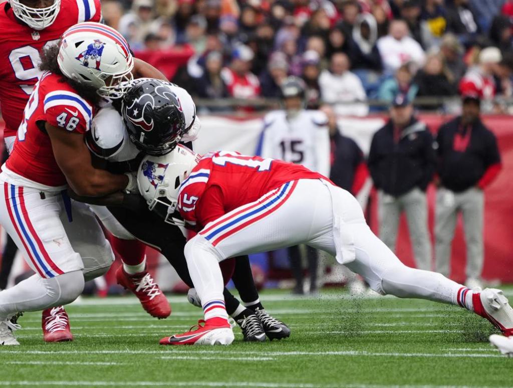 Oct 13, 2024; Foxborough, Massachusetts, USA; New England Patriots linebacker Jahlani Tavai (48) and New England Patriots safety Marte Mapu (15) tackles Houston Texans running back Dameon Pierce (31) during the second half at Gillette Stadium. Mandatory Credit: Gregory Fisher-Imagn Images