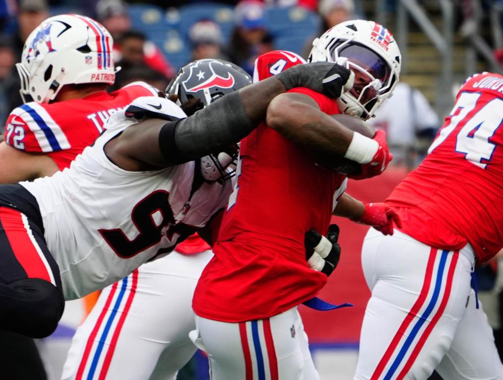 Oct 13, 2024; Foxborough, Massachusetts, USA; Houston Texans defensive tackle Mario Edwards Jr. (97) grabs New England Patriots running back Antonio Gibson (4) by the face mask when making a tackle during the second half at Gillette Stadium. Credit: Gregory Fisher-Imagn Images