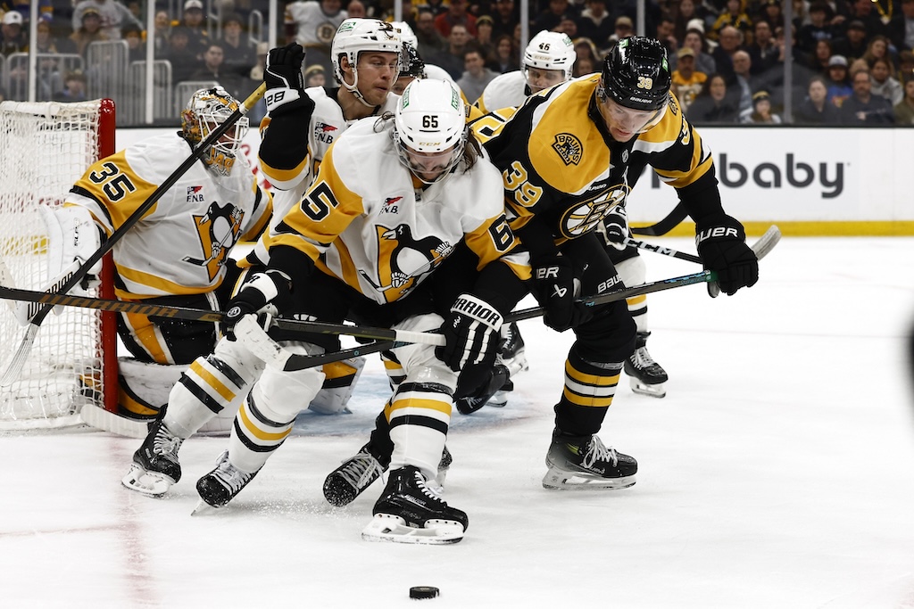 Nov 29, 2024; Boston, Massachusetts, USA; Pittsburgh Penguins defenseman Erik Karlsson (65) tries to hold off Boston Bruins center Morgan Geekie (39) from getting to the puck during the third period at TD Garden. Mandatory Credit: Winslow Townson-Imagn Images