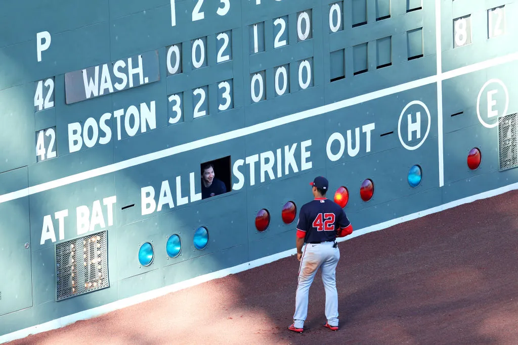 BOSTON, MASSACHUSETTS - AUGUST 30: Juan Soto #42 of the Washington Nationals talks with a scoreboard attendant working inside the Green Monster during the seventh inning of the game against the Boston Red Sox at Fenway Park on August 30, 2020 in Boston, Massachusetts. All players are wearing #42 in honor of Jackie Robinson Day. The day honoring Jackie Robinson, traditionally held on April 15, was rescheduled due to the COVID-19 pandemic. (Photo by Maddie Meyer/Getty Images)