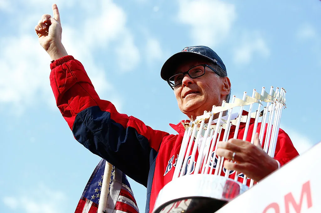 BOSTON, MA - NOVEMBER 02: Boston Red Sox owner John Henry holds up the World Series trophy during the World Series victory parade on November 2, 2013 in Boston, Massachusetts. (Photo by Jared Wickerham/Getty Images)