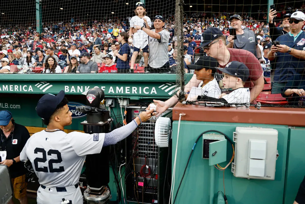 BOSTON, MA - JUNE 16: Juan Soto #22 of the New York Yankees signs autographs for young Yankee fans before their game against the Boston Red Sox at Fenway Park on June 16, 2024 in Boston, Massachusetts. (Photo By Winslow Townson/Getty Images)