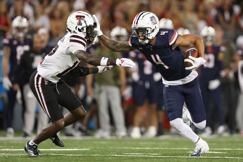 TUCSON, ARIZONA - OCTOBER 05: Wide receiver Tetairoa McMillan #4 of the Arizona Wildcats makes a reception against Macho Stevenson #12 of the Texas Tech Red Raiders during the first half of the NCAAF game at Arizona Stadium on October 05, 2024 in Tucson, Arizona. (Photo by Christian Petersen/Getty Images)