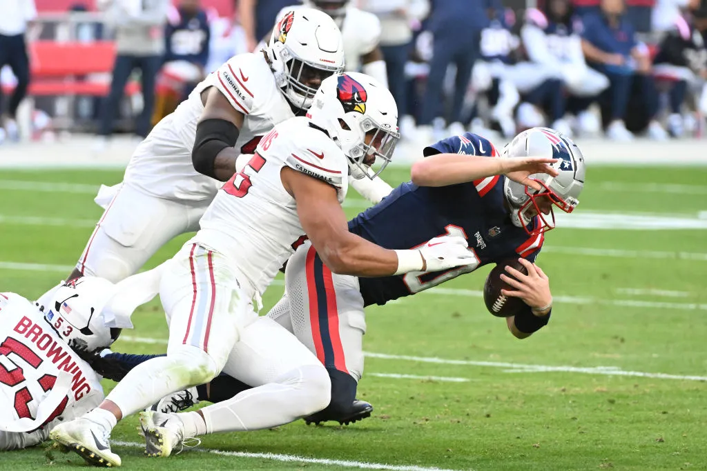 GLENDALE, ARIZONA - DECEMBER 15: Drake Maye #10 of the New England Patriots is tackled by Zaven Collins #25 of the Arizona Cardinals in the second quarter of the game at State Farm Stadium on December 15, 2024 in Glendale, Arizona. (Photo by Norm Hall/Getty Images)