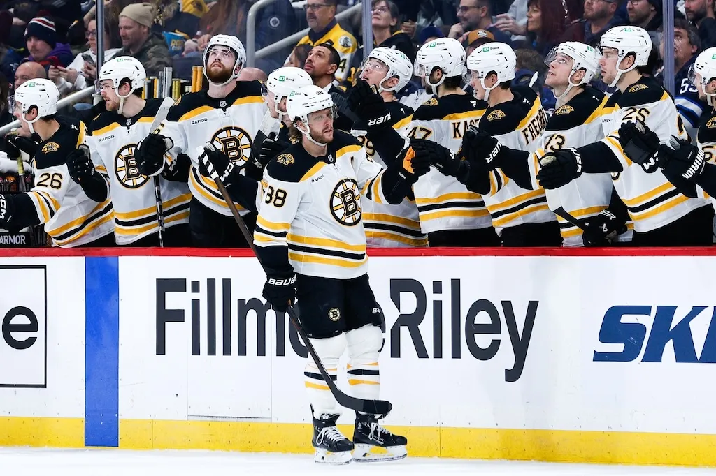 Dec 10, 2024; Winnipeg, Manitoba, CAN;  Boston Bruins forward David Pastrnak (88) is congratulated by his team mates on his goal against the Winnipeg Jets during the second period at Canada Life Centre. Mandatory Credit: Terrence Lee-Imagn Images