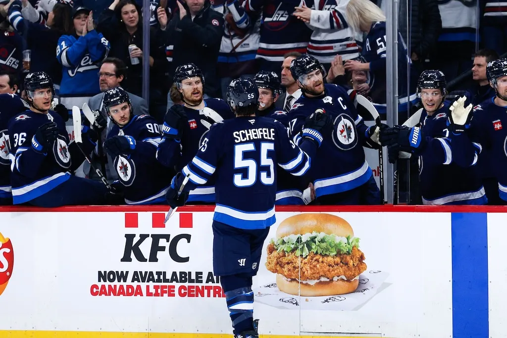 Dec 10, 2024; Winnipeg, Manitoba, CAN;  Winnipeg Jets forward Mark Scheifele (55) is congratulated by his team mates on his goal against the Boston Bruins during the second period at Canada Life Centre. Mandatory Credit: Terrence Lee-Imagn Images